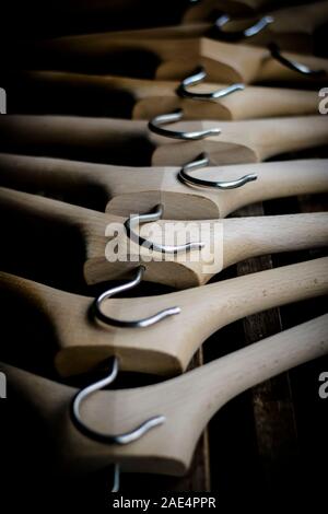 Una fila di coathangers in legno senza vestiti Foto Stock