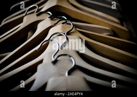 Una fila di coathangers in legno senza vestiti Foto Stock