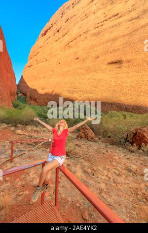 Tourist donna seduta sul balcone all'interno della gola lungo Walpa Gorge Walk in Uluru-Kata Tjuta National Park. Australian Outback Red Centre Foto Stock