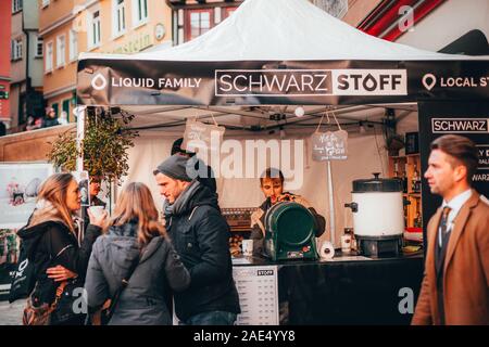 Tübingen, Germania - 6 Dicembre 2019: mercato del cioccolato chocolART con natale stand e bancarelle con molte persone in piedi in folla mulled potabile Foto Stock