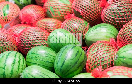 Fetta di anguria.Molti grandi dolci verdi cocomeri e un taglio di anguria. Foto Stock