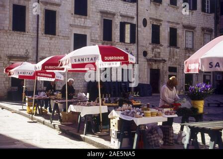 La gente del posto di impostazione di stallo upher al mercato all'aperto in Gunduliceva Poljana Square, paese vecchio di Dubrovnik, Croazia. Foto Stock