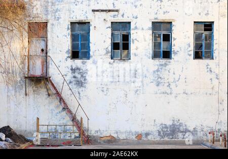 Abbandonato il vecchio edificio con facciata di vetro rotto Foto Stock