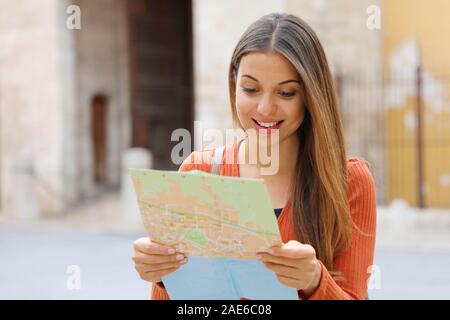 Ragazza di viaggio visitare città ricerca Direzione sulla mappa. Felice allegro turista femminile esplorando nuove città ricerca strada o posizione sulla mappa durante vacati Foto Stock