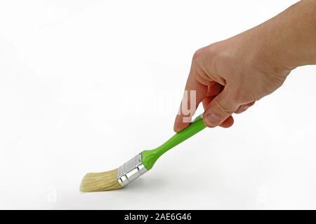 Maschio con mano verde spazzola di pittura isolati su sfondo bianco Foto Stock