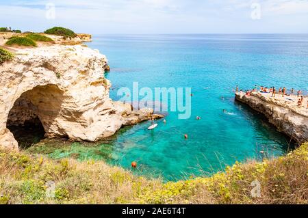 Tropea in Calabria, Italia - 09 Settembre 2019: persone diving dalla scogliera piatta, prendere il sole, nuotare nel mare cristallino dell'acqua sulla spiaggia rocciosa di Foto Stock