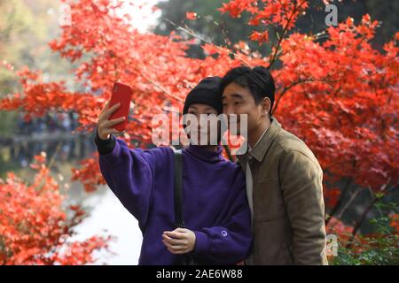 Changsha, provincia cinese di Hunan. Il 7 dicembre, 2019. I turisti prendono un selfie prima di foglie di acero su Yuelu Mountain a Changsha, centrale provincia cinese di Hunan, 7 dicembre, 2019. Credito: Xue Yuge/Xinhua/Alamy Live News Foto Stock