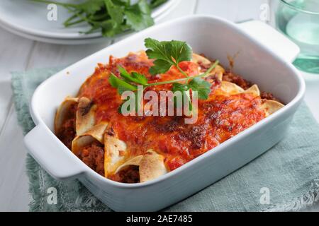 Tre enchiladas decorate con prezzemolo in una teglia closeup Foto Stock