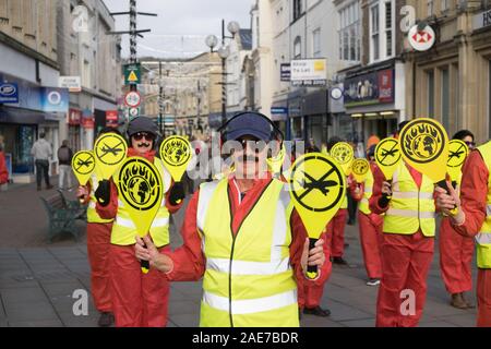 Weston-super-Mare, Somerset, Regno Unito, 7 dicembre 2019. La Ribellione di estinzione group stage una manifestazione di protesta nella città per protestare contro la prevista l'aeroporto di Bristol espansione. Vestito da direttori di pista con pipistrelli e falso baffi il gruppo ha fatto un segno di protesta sulla strada alta. Gli attivisti locali sono preoccupati per l'impatto ecologico dei piani di espansione per l'aeroporto di Bristol. Credito: Signor Standfast/Alamy Live News Foto Stock