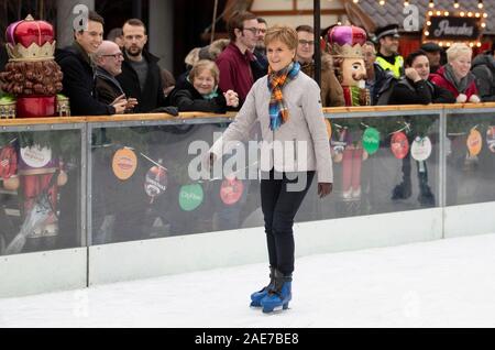 SNP leader Nicola Storione pattini da ghiaccio durante una visita alla Aberdeen Mercatino di Natale nel quad, Marischal College, sulla campagna elettorale trail. Foto Stock