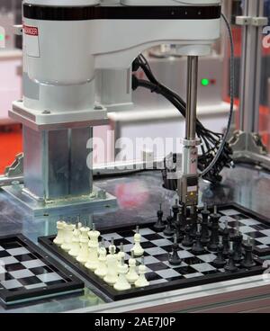 Un braccio di robot giocare gioco di scacchi Foto Stock