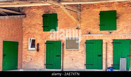 Rustico tradizionale fienile in mattoni rossi con porte dipinte di verde in una fattoria in Bassa Sassonia Germania. Foto Stock