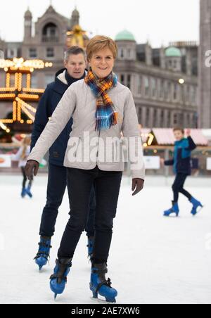 SNP leader Nicola Storione pattini da ghiaccio durante una visita alla Aberdeen Mercatino di Natale nel quad, Marischal College, sulla campagna elettorale trail. Foto Stock