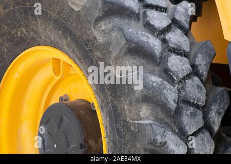 Fino chiudere la vista del pneumatico sul grande giallo il trattore. Foto Stock