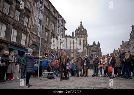 Edimburgo, Scozia, Regno Unito, 7 dicembre 2019. La colorata Mighty Gareth Street Performer da Londra ha viaggiato fino a eseguire il suo spettacolo sulla Royal Mile per intrattenere i turisti e gli amanti dello shopping che stavano passando attraverso la High Street prima della pioggia ha iniziato a cui è stato appena dopo le 2 pm e imbevuti di acquirenti su un tetro Princes Street. Foto Stock