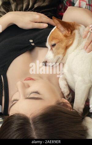 Giovane donna abbracciato con jack russell terrier sleeping closeup ritratto Foto Stock