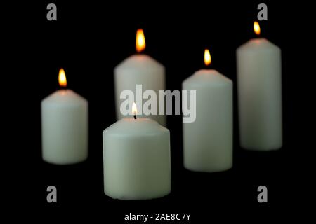 5 luce di candela di fiamma che brucia ardentemente su sfondo nero Foto Stock
