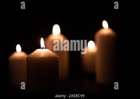 5 luce di candela di fiamma che brucia ardentemente su sfondo nero Foto Stock