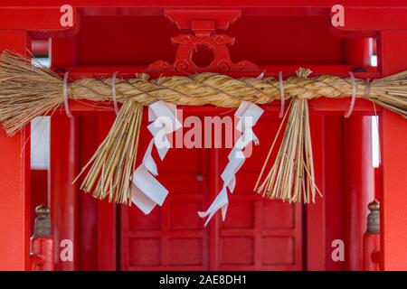 Close up della sacra di corda, o shimenawa e shide, carta streamers, a Nomachiinari sacrario scintoista a Kanazawa, Ishikawa Prefettura, Giappone occidentale. Foto Stock