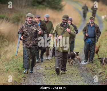 Gruppo di cacciatori armati di pistole e cani Foto Stock