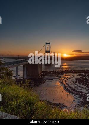 Aust, South Gloucestershire, England, Regno Unito - Giugno 08, 2019: Tramonto al Severn Bridge, che conduce oltre il fiume Severn, visto da Aust Cliff Foto Stock