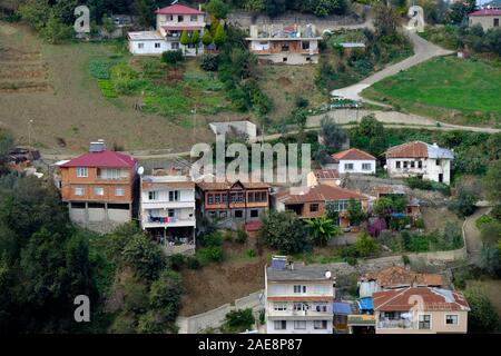 Case storiche incastonato tra edifici in cemento in akcaabat Ortamahalle Foto Stock