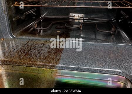 Vista dentro il forno elettrico con una metà lucida e pulita altro lato sporco sporco coperti di grasso bruciato e cibo . Il servizio di pulizie concetto e confronto Foto Stock