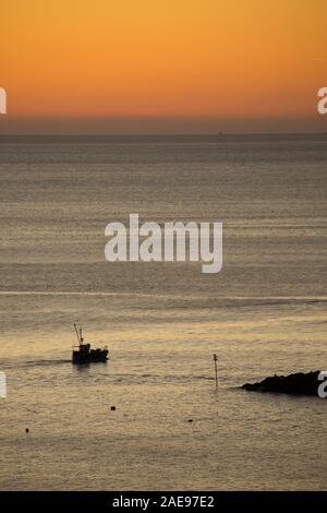 Una fascia costiera di barca da pesca che ha lasciato il porto di Lyme Regis voce fuori all'alba di un gelido mattino all'inizio di dicembre 2019. Lyme Regis Foto Stock