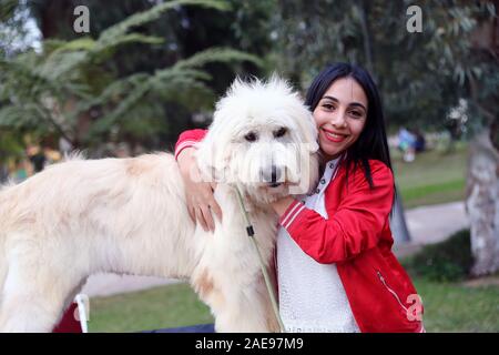 Il Cairo, Egitto. 6 dicembre, 2019. Una ragazza pone con un cane durante un carnevale di pet al Cairo, in Egitto, il 6 dicembre 2019. Tenuto presso il giardino del Cairo del centro infantile per la civiltà e la creatività, Aleef quarta Aria Aperta animali domestici di Carnival, che ha dato dei calci a fuori il venerdì, ha attirato migliaia di proprietari di animali da compagnia e gli amanti. Credito: Ahmed Gomaa/Xinhua/Alamy Live News Foto Stock