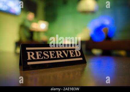 Riservati sign in piedi sul tavolo di legno in bar Foto Stock