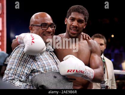 Anthony Joshua con suo padre Robert Joshua dopo la riconquista della IBF, WBA, WBO & IBO World Heavyweight Championship cinghie da Andy Ruiz (non illustrato) all'Arena di Diriyah, Diriyah, Arabia Saudita. Foto Stock