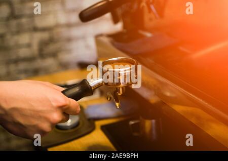 Il processo per la fabbricazione di caffè nella caffetteria cafe. Chiusura del barista preparare espresso fresco Foto Stock