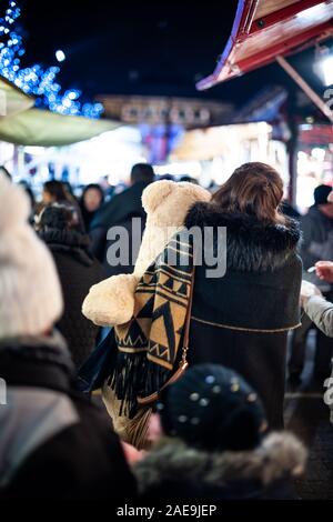 Strasburgo, Francia - Dic 20, 2016: vista posteriore della giovane donna che porta grande orso bianco toy tra le bancarelle del mercato annuo del mercato di Natale a Strasburgo Foto Stock