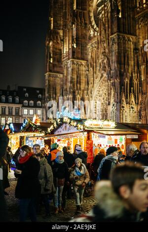 Strasburgo, Francia - Dic 20, 2016: francese street con un grande gruppo di persone ammirando l'annuale Mercato di Natale Marche de Noel con più bancarelle del mercato e la Cattedrale di Notre Dame de la cattedrale di Strasburgo Foto Stock