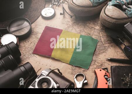 Bandiera della Guinea tra Traveler's accessori sul vecchio Vintage map. Destinazione turistica concetto. Foto Stock