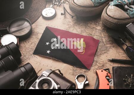 Papua Nuova Guinea bandiera tra Traveler's accessori sul vecchio Vintage map. Destinazione turistica concetto. Foto Stock