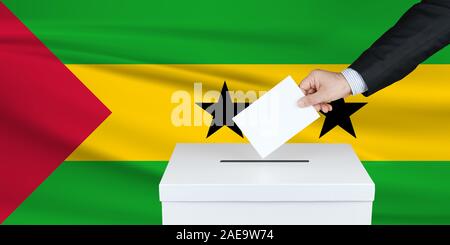 Elezione a Sao Tomé. La mano dell'uomo che mette il suo voto nella cassa di voto. Bandiera di Sao Tome ondulato sullo sfondo. Foto Stock