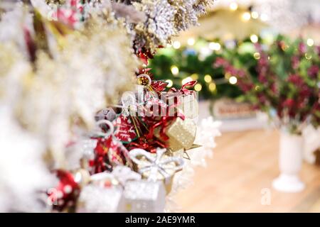 Shopping di Natale morbido sfondo selettivo del fuoco per l'oro piccolo e bianco decorazione dell'albero di Natale splendente in negozio di regali. Foto Stock