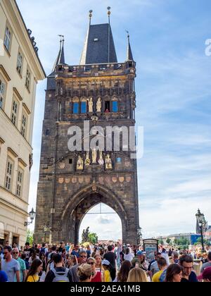 Folla di turisti che camminano attraverso l'arco della Torre del Ponte della Città Vecchia al bordo del Ponte Carlo Praga Repubblica Ceca. Foto Stock
