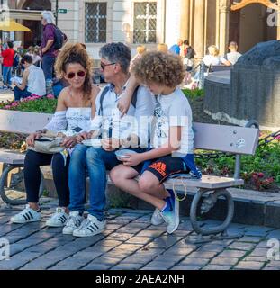 Famiglia di padre e figlio seduto su una panchina per uno spuntino nella Piazza della Città Vecchia di Praga Repubblica Ceca. Foto Stock