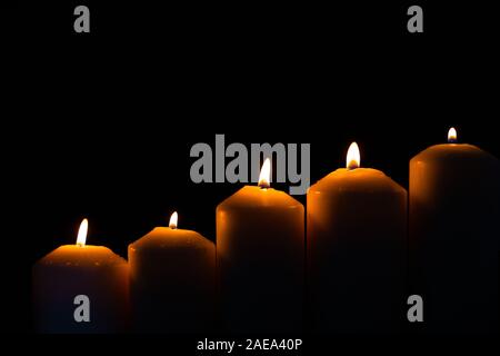 5 luce di candela di fiamma che brucia ardentemente su sfondo nero Foto Stock