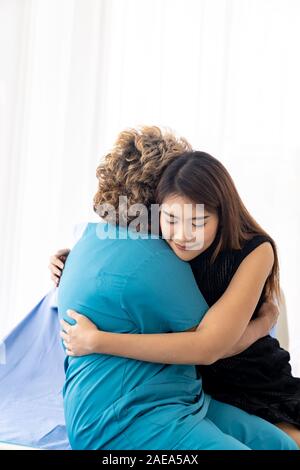 Carino giovane figlia abbracciando abbraccio la sua felice vecchia madre anziana con amore a casa Foto Stock