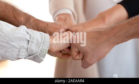 Close up diversi compagni di squadra unendo i pugni, condivisione comune successo. Foto Stock