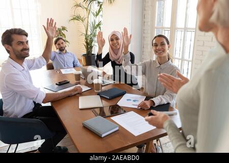 Felice razza mista giovani colleghi di votare per le decisioni. Foto Stock