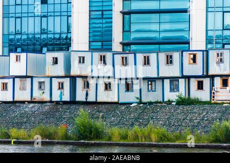 Operai di case temporanee in righe vicino al nuovo edificio in Russia Foto Stock