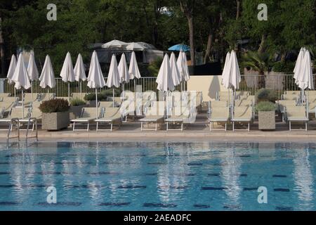 Lettini ed ombrelloni in piscina Foto Stock