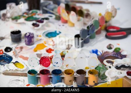 Vista dall'alto sulla pittura set di spazzole, vernici, acquerello, Vernice acrilica su uno sfondo bianco. Set di pennelli e colori sul tavolo nell'asilo nido. C Foto Stock