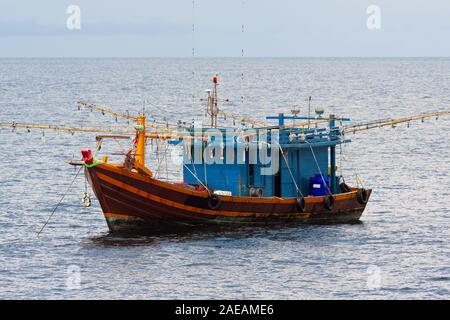 Barche da pesca sono prepotentemente in mezzo al mare su un bel cielo azzurro. Foto Stock