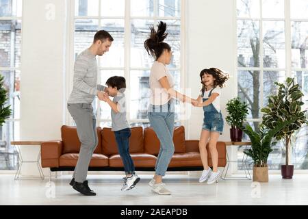 Felice madre e padre di due figli di saltare in ballo. Foto Stock