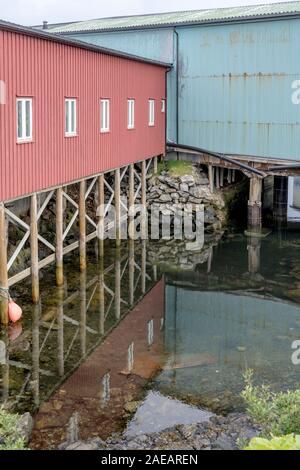 Paesaggio con stilt magazzini al artic villaggio turistico porto, girato sotto la luminosa luce torbida a Andenes, Andoya, Vesteralen, Norvegia Foto Stock